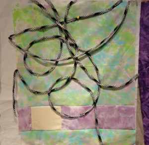 Light green and pale purple background with black and white bias loops pined to the surface.