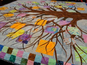 Mulit colored tree crown with childres' hands amoung the branches.