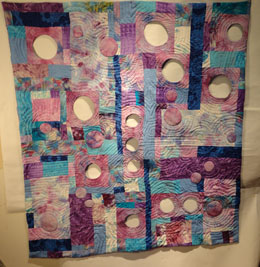 Full shot of the quilt with the wholes faces and the quilting done.