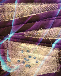 close up showig the angelina and sequins on the purple fabric