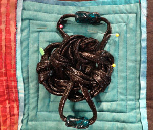 Close up of one of the knots pinned to the quilt top