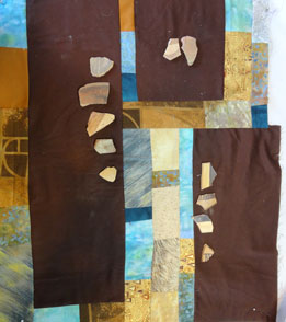 Blue and brown quilt with pot shards on top