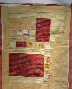 Photo of crimson and tan quilt with paper added on top