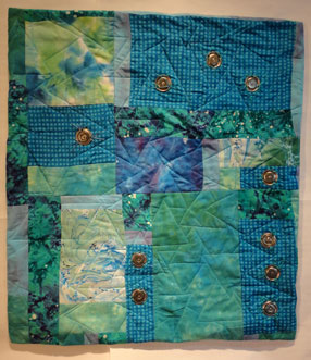 full shot of the truquoise and green quilt with the matal add ons