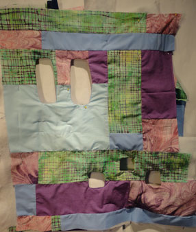 Shot of purpe and green quilt with five wholes 