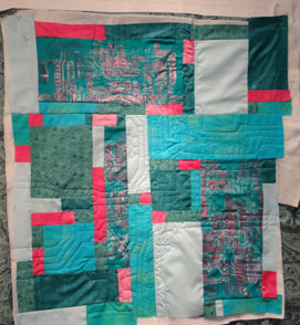 Shot of turquoies and fushe quilt showing the beginning of quilting